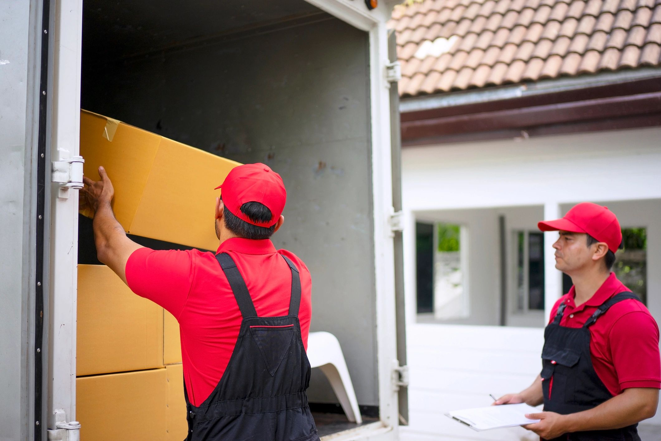 Mover carrying boxes into a home