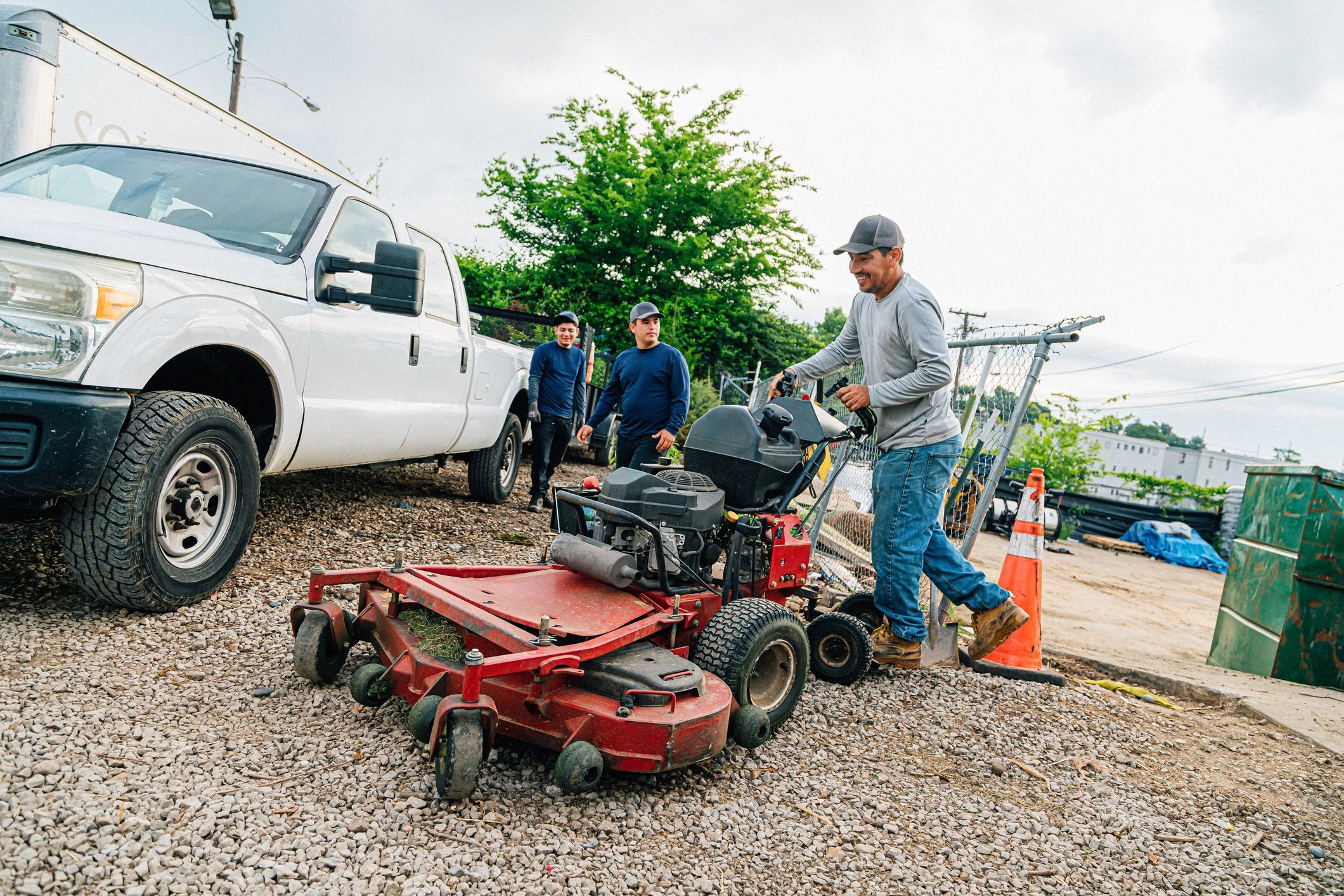 Landscaping professional loading a riding mower for lawn care